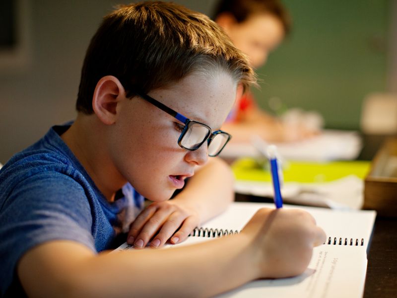 Young boy working on the school work after successful ADHD treatment