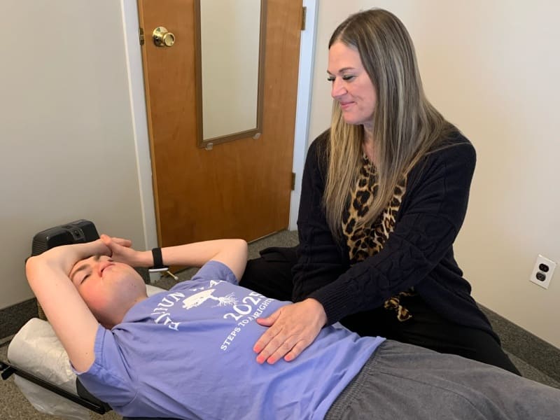 Female chiropractic neurologist working with a teenage boy during ADHD treatment session